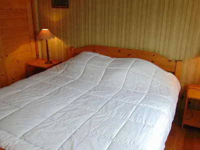 a large white bed in a bedroom with a lamp at Charmant 3 pièces avec terrasse, parking, 6 couchages - Chamonix - FR-1-517-38 in Chamonix-Mont-Blanc