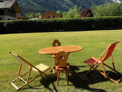 a wooden table and two chairs around a table at Charmant 3 pièces avec terrasse, parking, 6 couchages - Chamonix - FR-1-517-38 in Chamonix-Mont-Blanc