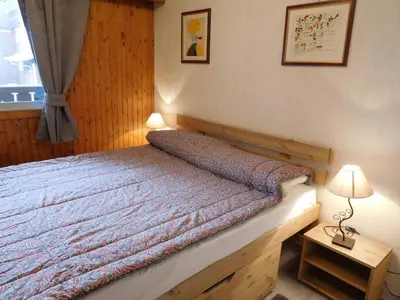 a bedroom with a bed and a table with a lamp at Appartement 2 pièces Chamonix avec Parking - FR-1-517-39 in Chamonix-Mont-Blanc