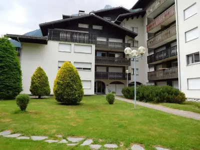 an apartment building with a lawn in front of it at Appartement 2 pièces Chamonix avec Parking - FR-1-517-39 in Chamonix-Mont-Blanc