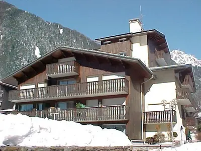 a large building with a balcony in the snow at Appartement 2 pièces Chamonix avec Parking - FR-1-517-39 in Chamonix-Mont-Blanc
