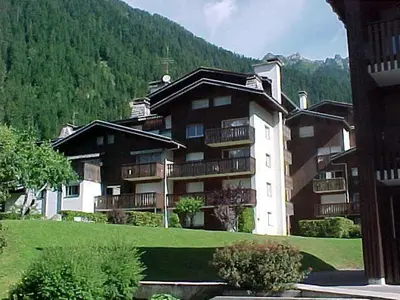 a large building with balconies and a mountain at Appartement 2 pièces Chamonix avec Parking - FR-1-517-39 in Chamonix-Mont-Blanc