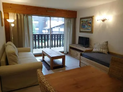 a living room with a couch and a tv at Appartement 2 pièces Chamonix avec Parking - FR-1-517-39 in Chamonix-Mont-Blanc