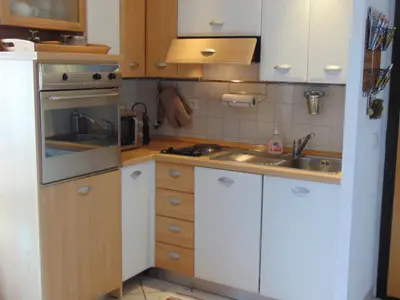 a small kitchen with white cabinets and a sink at Charmant 2 Pièces Central avec Terrasse - Chamonix - FR-1-517-41 in Chamonix-Mont-Blanc