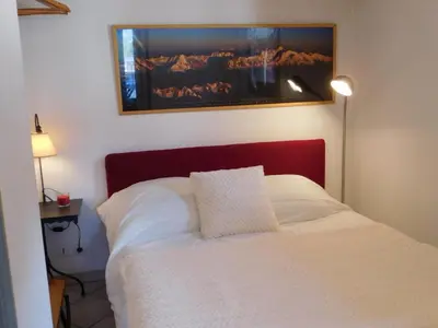a bedroom with a white bed with a picture on the wall at Charmant 2 Pièces Central avec Terrasse - Chamonix - FR-1-517-41 in Chamonix-Mont-Blanc