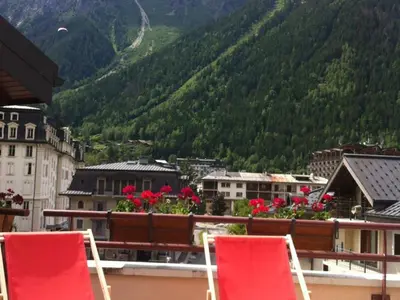 two red chairs sitting on a balcony with a mountain at Charmant 2 Pièces Central avec Terrasse - Chamonix - FR-1-517-41 in Chamonix-Mont-Blanc