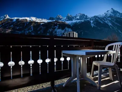 a table and chairs on a balcony with mountains at Studio Chamonix 5 pers, balcon, parking, animaux ok - FR-1-517-45 in Chamonix-Mont-Blanc