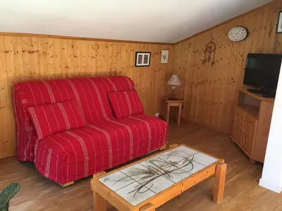 a living room with a red couch and a table at Bel appartement rénové à Chamonix avec vue sur le Mont-Blanc, parking et animaux admis - FR-1-517-51 in Chamonix-Mont-Blanc