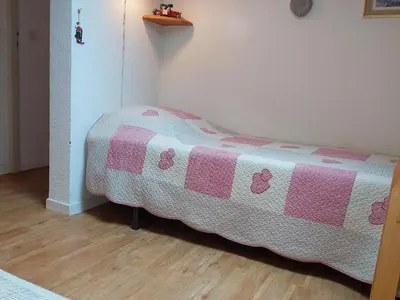 a bedroom with a bed with a pink and white blanket at Bel appartement rénové à Chamonix avec vue sur le Mont-Blanc, parking et animaux admis - FR-1-517-51 in Chamonix-Mont-Blanc