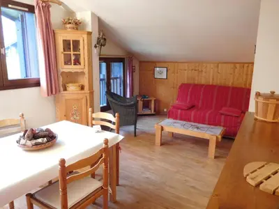 a living room with a red couch and a table at Bel appartement rénové à Chamonix avec vue sur le Mont-Blanc, parking et animaux admis - FR-1-517-51 in Chamonix-Mont-Blanc