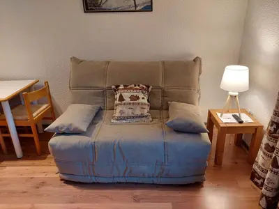 a blue ottoman with a pillow on top of it at 2 Pièces Sud-Est Chamonix, Parking & Animaux admis - FR-1-517-54 in Chamonix-Mont-Blanc