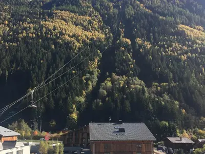 a mountain with a house in front of it at 2 Pièces Sud-Est Chamonix, Parking & Animaux admis - FR-1-517-54 in Chamonix-Mont-Blanc