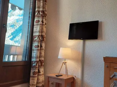 a room with a tv and a lamp and a window at 2 Pièces Sud-Est Chamonix, Parking & Animaux admis - FR-1-517-54 in Chamonix-Mont-Blanc