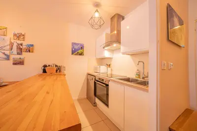 a kitchen with white cabinets and a wooden counter top at Apartment Arve - Chamonix Peaks Retreat in Chamonix-Mont-Blanc