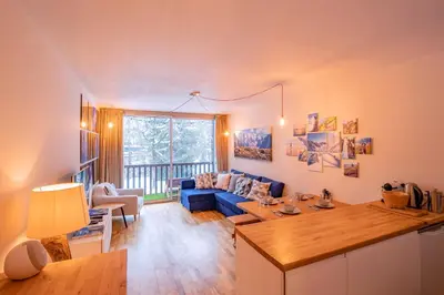 a living room with a blue couch and a table at Apartment Arve - Chamonix Peaks Retreat in Chamonix-Mont-Blanc