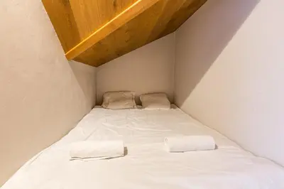 a bed in a small room with two pillows on it at Apartment Genevrier - Spacious Balcony with Mont Blanc Views in Chamonix-Mont-Blanc
