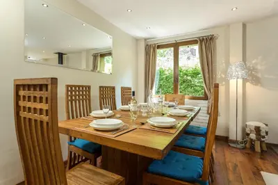 a dining room with a wooden table and chairs at Villa Loppe - Chamonix Mountain Four-Bedroom Hidden Gem in Chamonix-Mont-Blanc