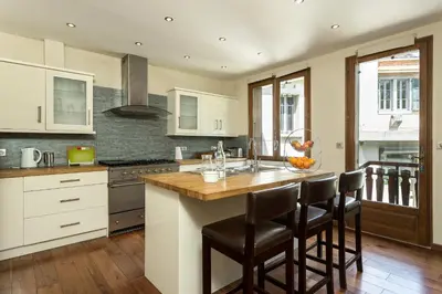 a kitchen with a island with bar stools at Villa Loppe - Chamonix Mountain Four-Bedroom Hidden Gem in Chamonix-Mont-Blanc