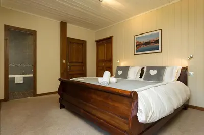 a bedroom with a large bed and a bath room at Villa Loppe - Chamonix Mountain Four-Bedroom Hidden Gem in Chamonix-Mont-Blanc