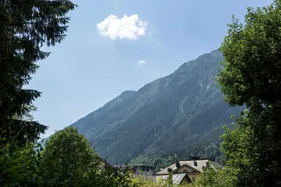 a small cloud in the sky over a mountain at Villa Loppe - Chamonix Mountain Four-Bedroom Hidden Gem in Chamonix-Mont-Blanc