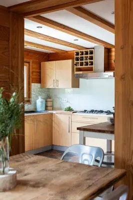 a kitchen with wooden cabinets and a table and chairs at Chalet La Chaumière in Chamonix-Mont-Blanc