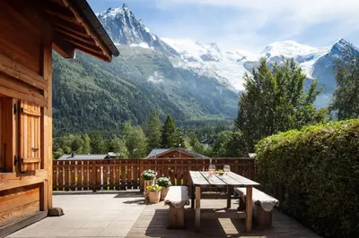 a patio with a table and a view of mountains at Chalet La Chaumière in Chamonix-Mont-Blanc