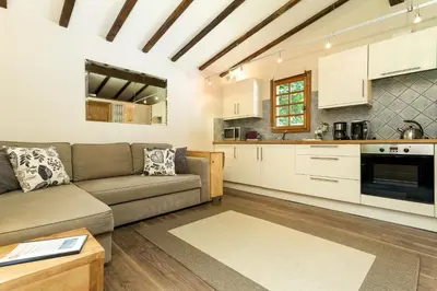 a living room with a couch and a kitchen at Mazot Loppe - A Cosy Central Chamonix Hideaway in Chamonix-Mont-Blanc
