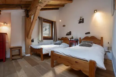 a bedroom with a large bed and a wooden cabinet at Appartement Clusettes - Happy Rentals in Chamonix-Mont-Blanc