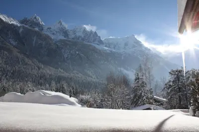 a snow covered mountain with the sun in the background at Les Chalets des Liarets in Chamonix-Mont-Blanc