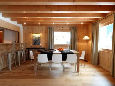 a dining room with a table and white chairs at Les Chalets des Liarets in Chamonix-Mont-Blanc
