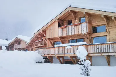 a large wooden house with snow on the ground at Les Chalets des Liarets in Chamonix-Mont-Blanc