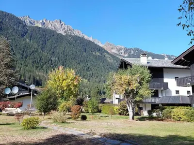 a house with a mountain in the background at Superbe 3 pièces Chamonix - Jardin privé - Parking - Animaux admis - FR-1-517-25 in Chamonix-Mont-Blanc