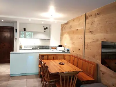 a kitchen with a wooden table and a wooden wall at Superbe 3 pièces Chamonix - Jardin privé - Parking - Animaux admis - FR-1-517-25 in Chamonix-Mont-Blanc