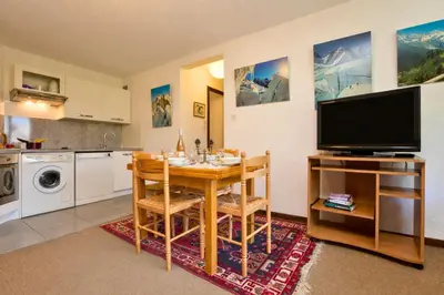 a kitchen with a dining room table with a television at Appartement Lachenal 209A - Happy Rentals in Chamonix-Mont-Blanc