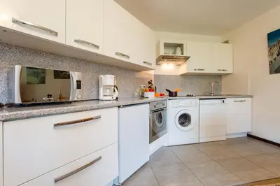 a kitchen with white cabinets and a washer and dryer at Appartement Lachenal 209A - Happy Rentals in Chamonix-Mont-Blanc