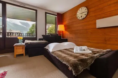 a bedroom with a bed and a clock on the wall at Appartement Lachenal 209A - Happy Rentals in Chamonix-Mont-Blanc