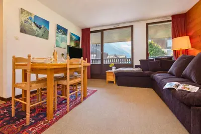a living room with a table and a couch at Appartement Lachenal 209A - Happy Rentals in Chamonix-Mont-Blanc