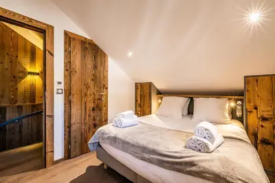 a bedroom with a large bed with towels on it at Le Globe Argentière Chamonix - by EMERALD STAY in Chamonix-Mont-Blanc