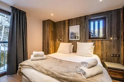 two beds in a bedroom with wooden walls at Le Globe Argentière Chamonix - by EMERALD STAY in Chamonix-Mont-Blanc