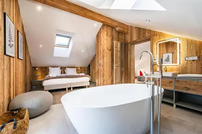 a bathroom with a white tub and a bedroom at Le Globe Argentière Chamonix - by EMERALD STAY in Chamonix-Mont-Blanc