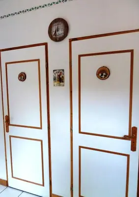 two doors in a room with a clock on the wall at Studio chaleureux à Saint-Gervais-les-Bains, 23m², vue montagne in Saint-Gervais-les-Bains