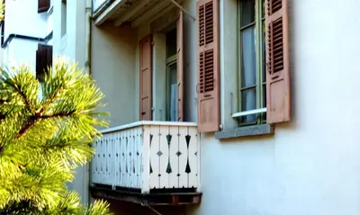 a building with a balcony and a palm tree at Studio chaleureux à Saint-Gervais-les-Bains, 23m², vue montagne in Saint-Gervais-les-Bains