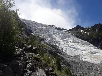 a river with snow on the side of a mountain at Studio chaleureux à Saint-Gervais-les-Bains, 23m², vue montagne in Saint-Gervais-les-Bains