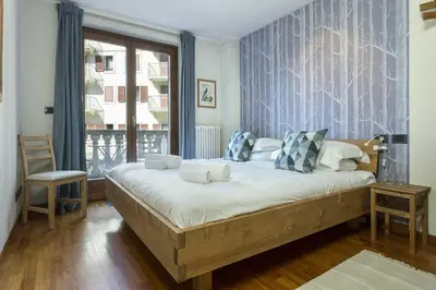 a bedroom with a large bed and a window at APARTMENT ENSA - Alpes Travel - Central Chamonix - Sleeps 4 in Chamonix-Mont-Blanc