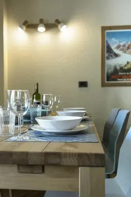 a wooden table with a plate and wine glasses at APARTMENT ENSA - Alpes Travel - Central Chamonix - Sleeps 4 in Chamonix-Mont-Blanc