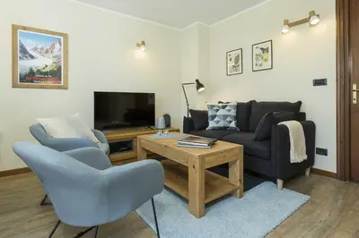 a living room with a couch and a tv at APARTMENT ENSA - Alpes Travel - Central Chamonix - Sleeps 4 in Chamonix-Mont-Blanc