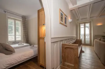 a room with a bed and a door with a window at Lutetia Apartment - Chamonix All Year in Chamonix-Mont-Blanc