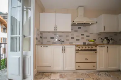 a kitchen with white cabinets and a stove at Lutetia Apartment - Chamonix All Year in Chamonix-Mont-Blanc