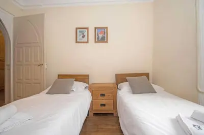 a bedroom with two beds and a wooden dresser at Lutetia Apartment - Chamonix All Year in Chamonix-Mont-Blanc