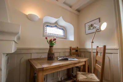 a room with a table with a lamp and flowers on it at Lutetia Apartment - Chamonix All Year in Chamonix-Mont-Blanc